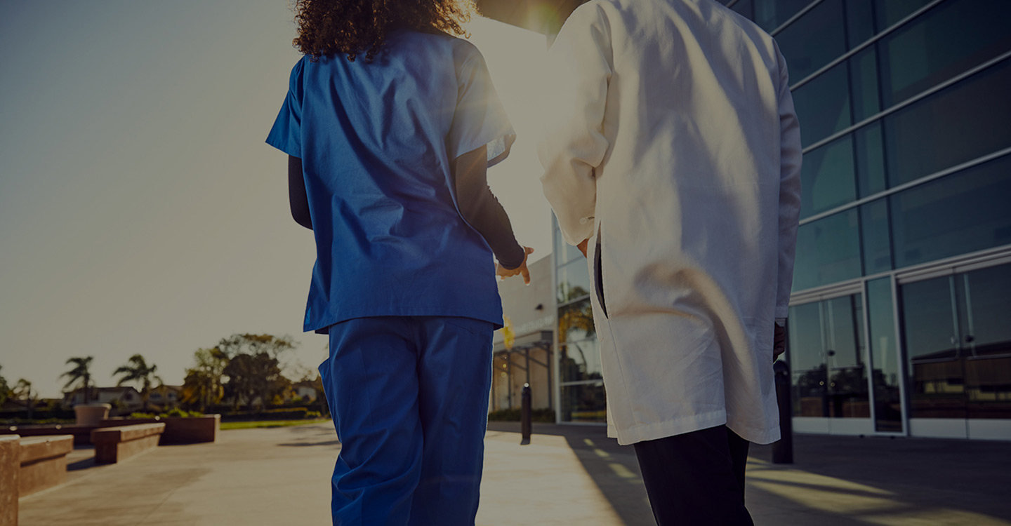 A Florida cardiologist and cardiac specialist walking outside a AdventHealth Cardiovascular Institute 