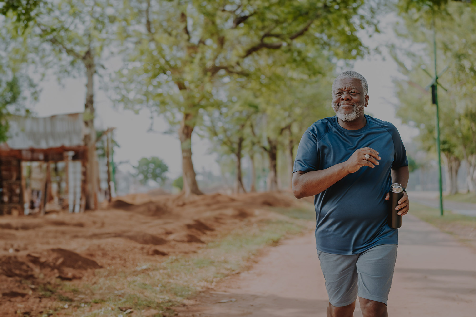 An older man running in the park.