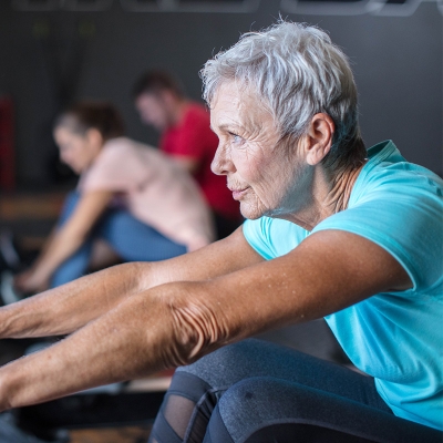 Female exercising on a rowing machine to prevent coronary artery disease