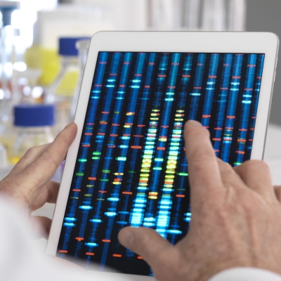 Hands holding a tablet with genomics results